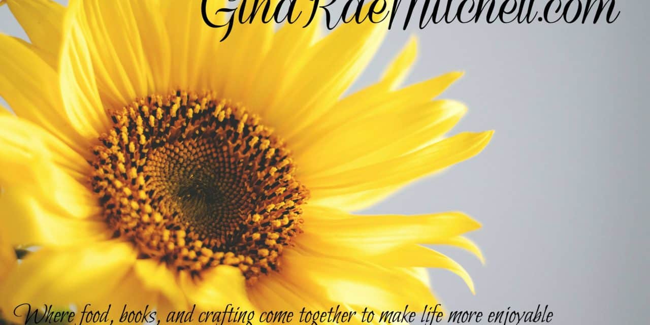 August 12 - 2018 newsletter yellow sunflower on blue sky background with phrase GinaRaeMitchell.com Where food, books, and crafting come together to make life more enjoyable