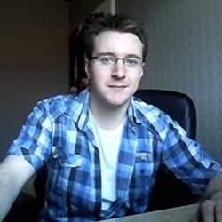 Thom Bedford profile image, young man with pale skin, dark hair, glasses, and a blue plaid shirt
