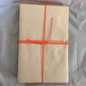 book wrapped in parcel paper with a ribbon