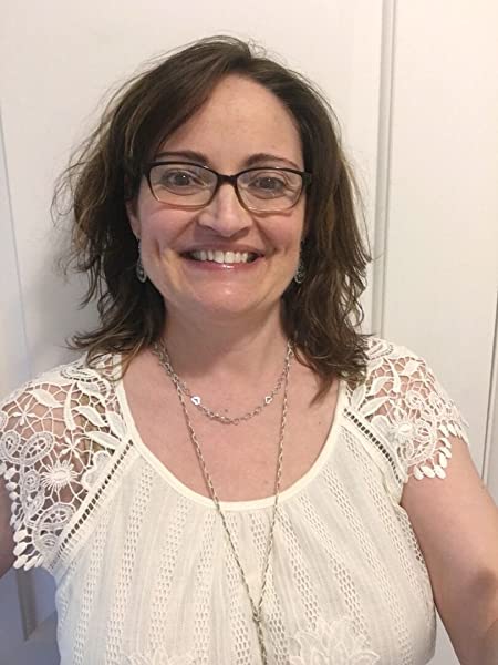 An author profile image of Ellwyn Autumn with a beautiful smile, brown hair and glasses, wearing a cream top with short crochet sleeves, in front of a neutral background.