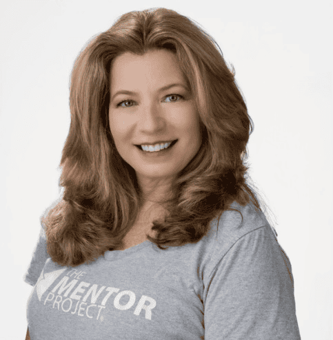 Professional headshot of a smiling woman wearing a gray T-shirt, photographed against a light neutral background, used as an author profile image.