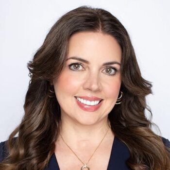 Author Jennifer Musser, smiling in a professional headshot with brown hair, wearing a dark business top