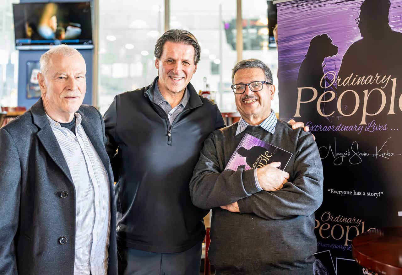 Ordinary People, Extraordinary Lives by Naguib Sami Kerba ~ Non-Fiction | Photo Biographies | Real-Life Reflections | $20 Gift Card 16 “Author Naguib Sami Kerba posing with two men during a book event for Ordinary People, Extraordinary Lives. He holds a copy of the book with a promotional banner in the background.”
