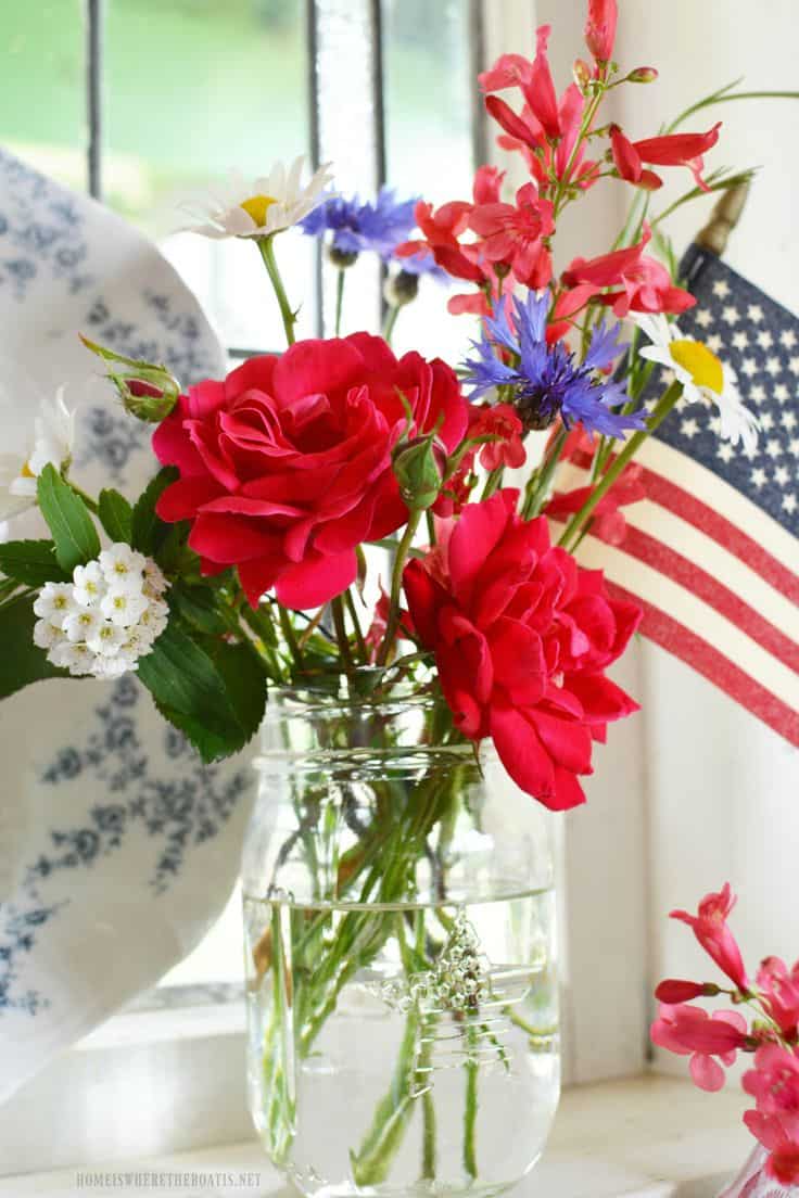 Red,White, Blue flowers in a mason jar with a small flag table decor