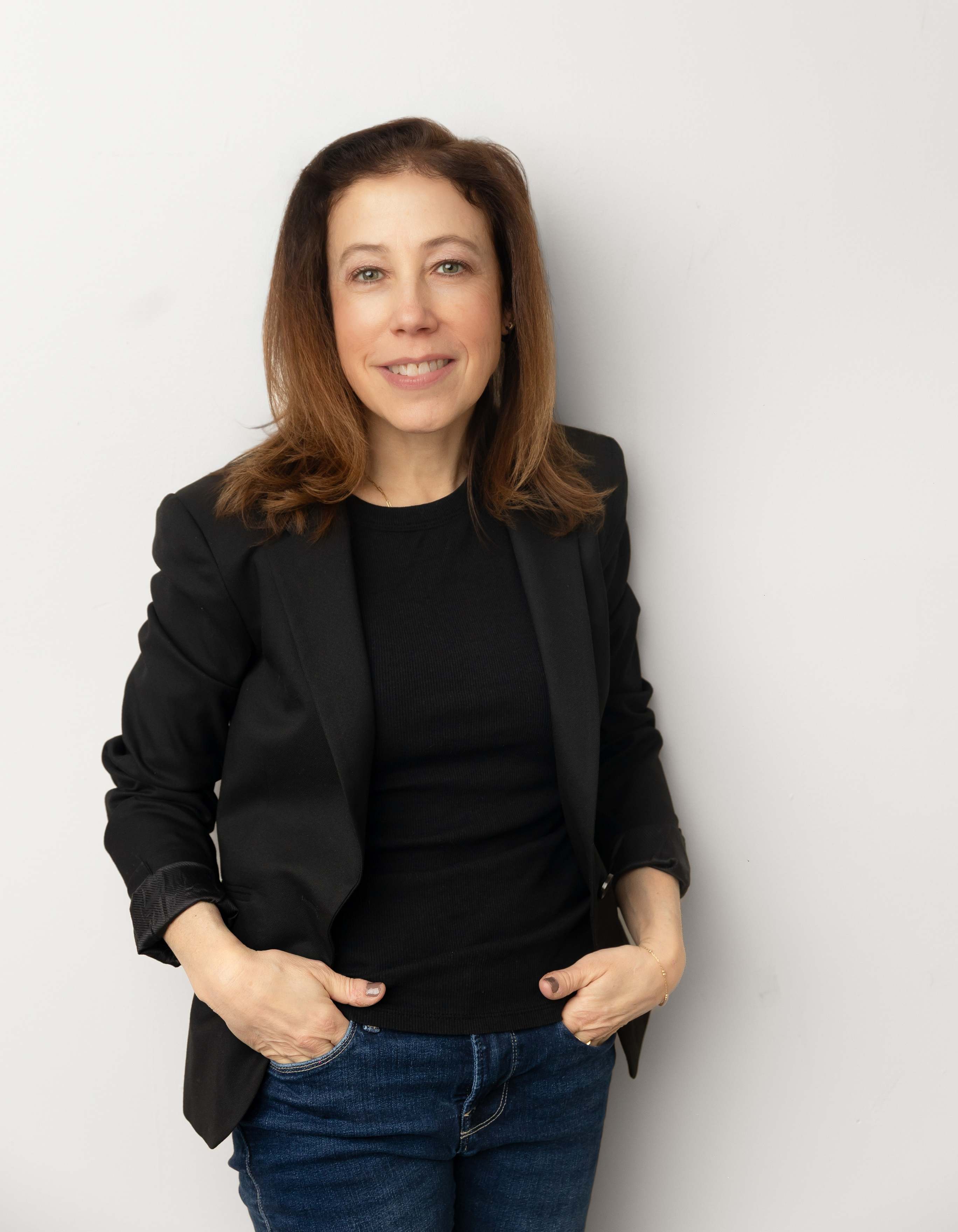 Author photo of Jessica Coriat, smiling in a black blazer and jeans against a plain white background.