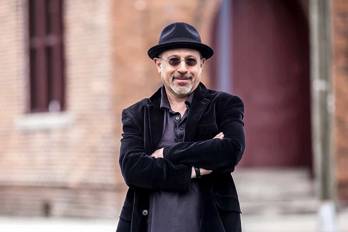 Author Guest Post and Spotlight | Extraterrestrial Noir by Rich Leder 10 Portrait of author Rich Leder standing outdoors with arms crossed, wearing a black jacket, dark shirt, and hat. The blurred brick background highlights his confident, creative personality as the author of Extraterrestrial Noir