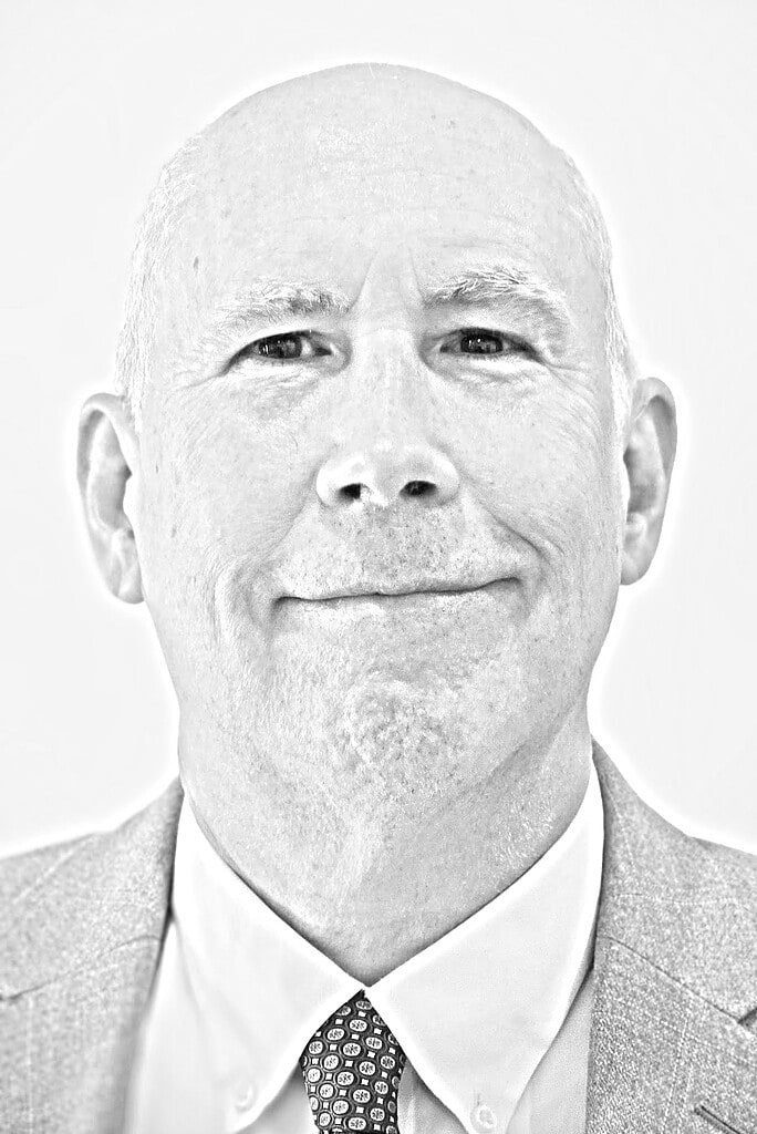 Spotlight & Author Guest Post | Tamanrasset: Crossroads of the Nomad by Edward Parr 10 Black-and-white headshot of author Edward Parr wearing a light jacket, white shirt, and patterned tie. He smiles gently at the camera.