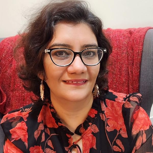 Author image of Narshita Nanda dark hair, dangling earrings, red and black print blouse, seated in an office chair with a red throw behind her