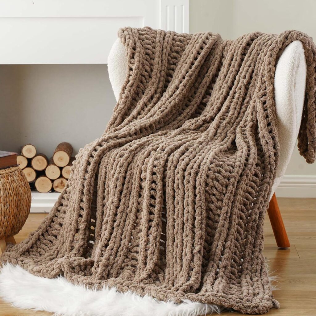 Taupe chunky knit throw blanket draped over a chair near a fireplace