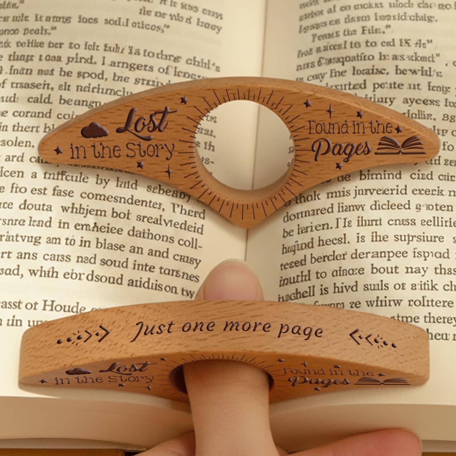 Wooden book thumb page holder on an open book, engraved with "Lost in the Story" and "Found in the Pages" and the phrase "Just one more page."