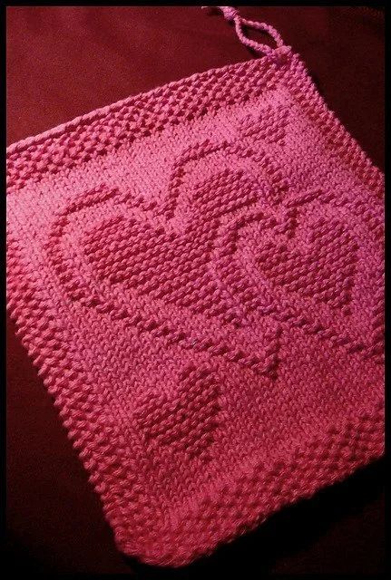 A rosy-red knitted dishcloth featuring 3-D raised hearts - Free pattern