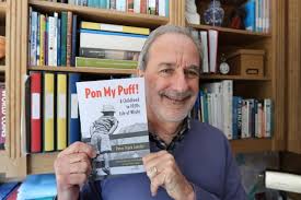 Charles Morris Lansley holding the edited version of his father's book, Pon My Puff!, in front of a bookshelf