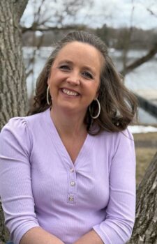 Jane Rogers author profile image used on GinaRaeMitchell.com showing Jane, smiling in a pink top against an outdoor setting