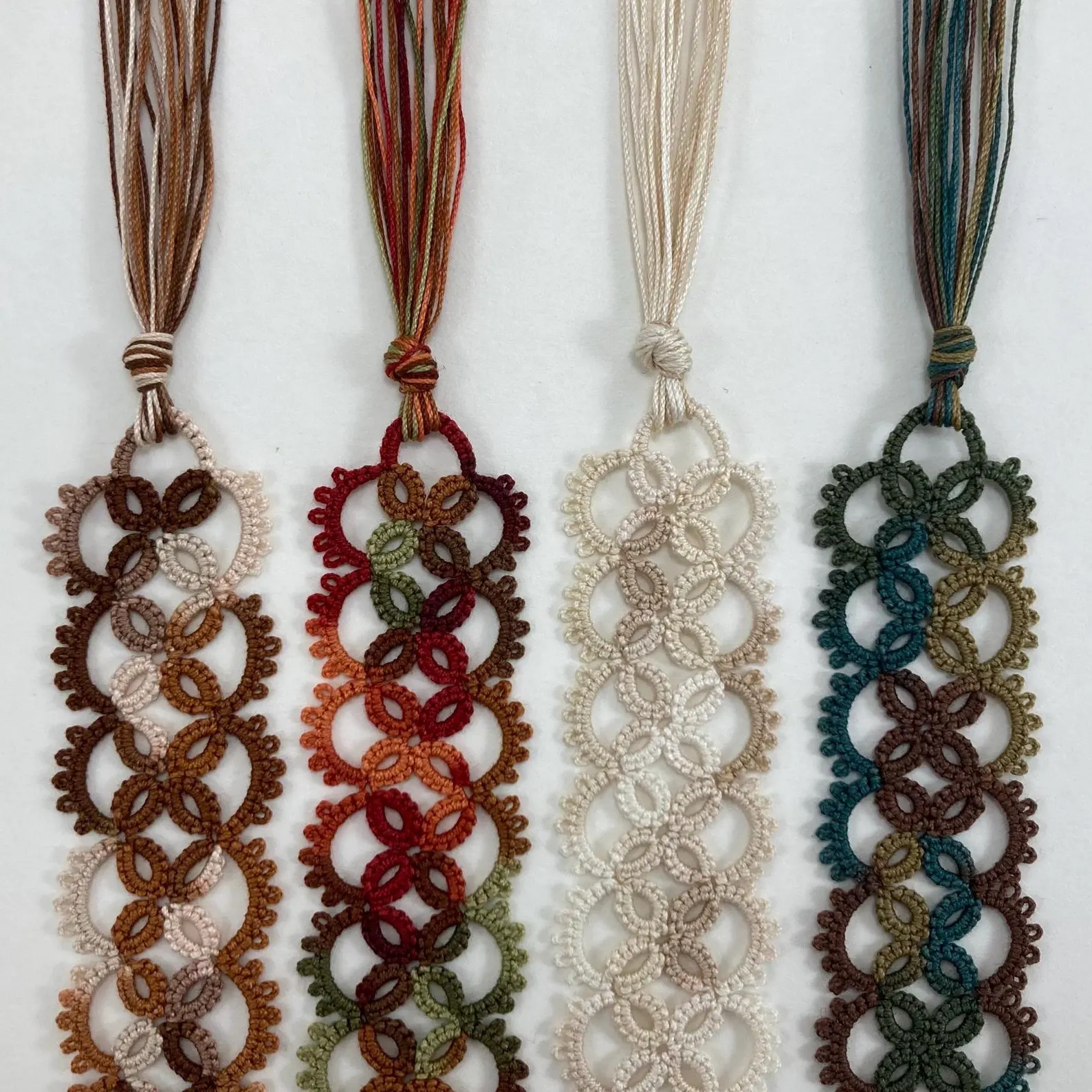 Handmade tatted lace bookmark in earth tones with intricate loop pattern and tassel