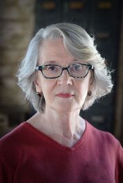 Author headshot of Victoria Weisfeld, writer of suspense novel She Knew Too Much.