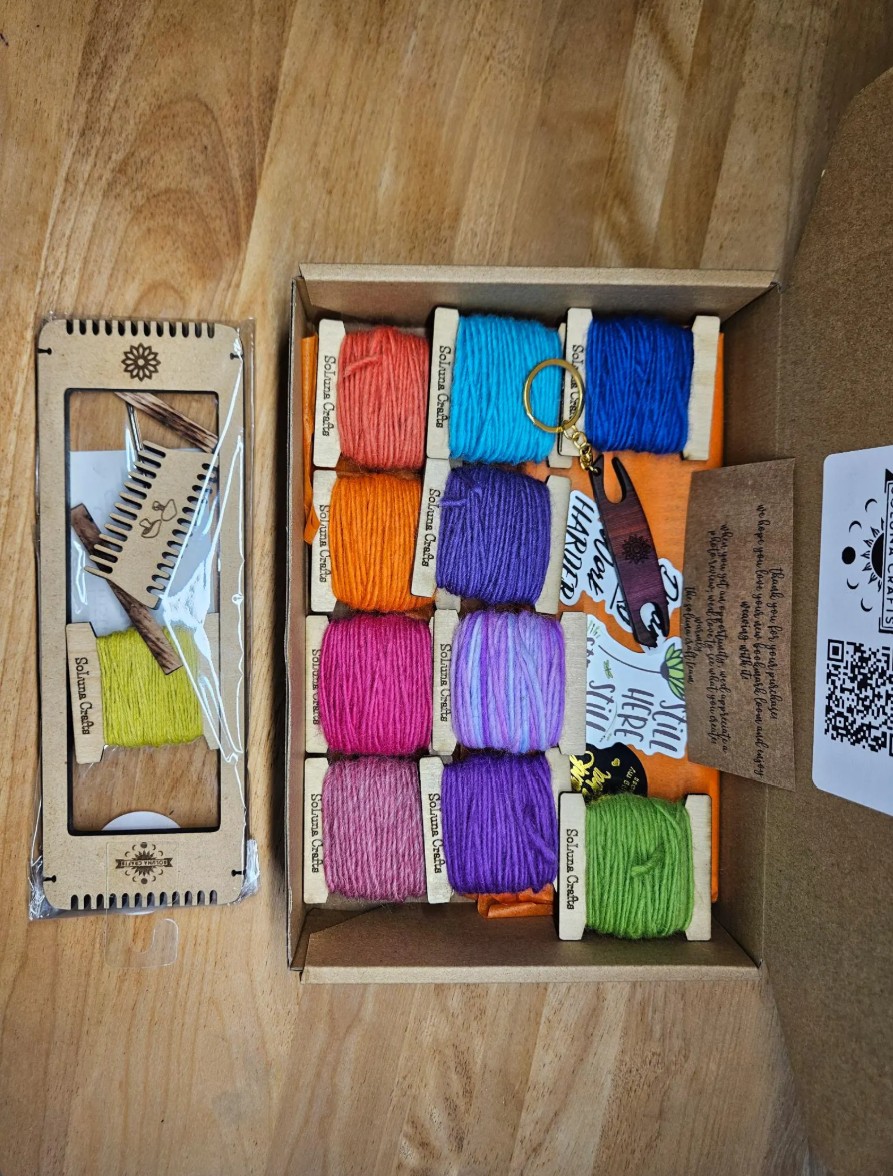 small pin loom weaving tool with colorful yarn swatches for beginner weaving projects