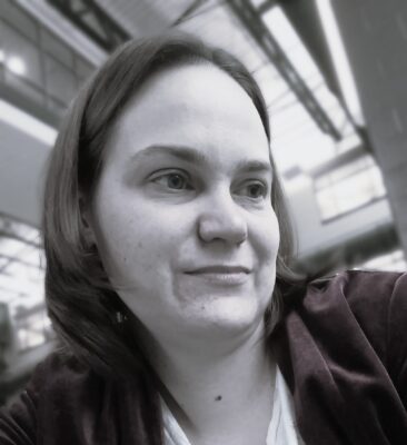 Author Jessica Rakus portrait in soft grayscale lighting looking slightly to the side with a calm expression