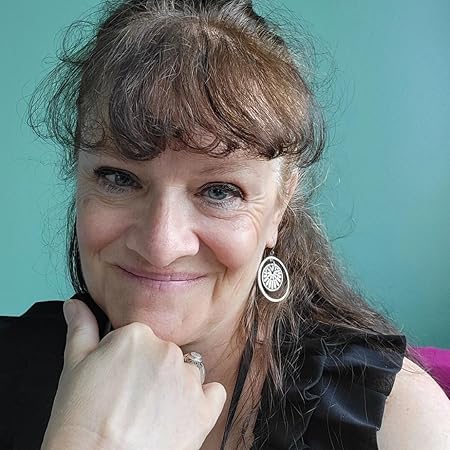 Missy-Tarantino-new-author-image-2025- Smiling with chin on hand, wearing a ruffly back top