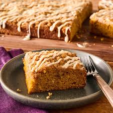 The Pioneer woman's Pumpkin coffee cake on a dark stoneware palte with the full cake in the background.